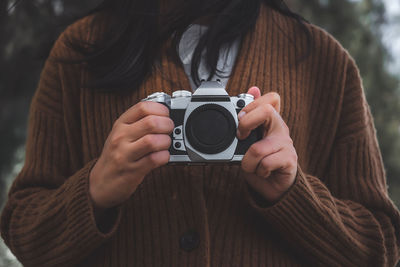 Midsection of woman holding camera