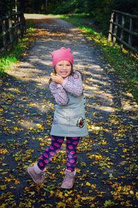 Portrait of a smiling girl standing in park during autumn