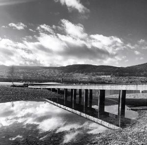 Pier on sea against cloudy sky