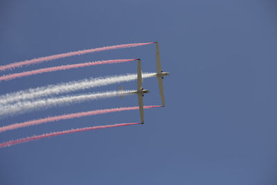 Low angle view of airplane flying against clear blue sky