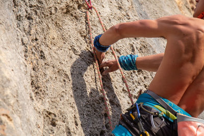 Midsection of person with rope against wall