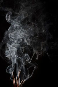 Close-up of illuminated lighting equipment against black background