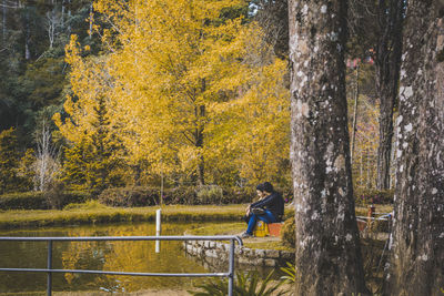 Couple amidst trees in forest during autumn