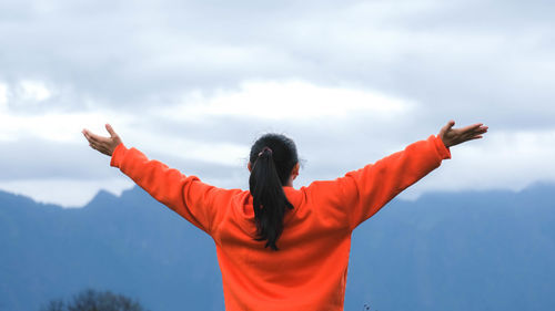 Rear view of woman standing against sky