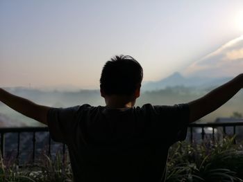 Rear view of man against sky during sunset