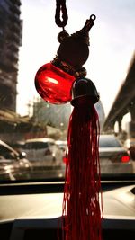 Close-up of red car hanging against sky