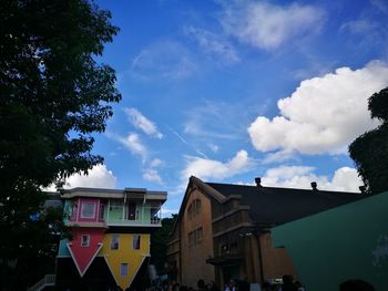 Low angle view of buildings against cloudy sky