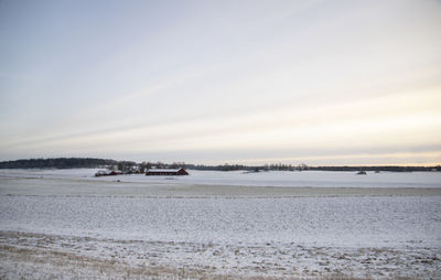 Scenic view of snow covered fields against sky during winter