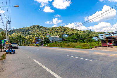 Road by street against sky
