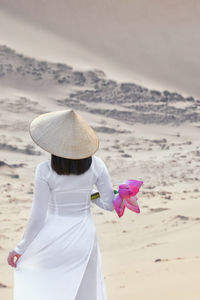 Rear view of woman with hat on beach