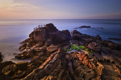 Rock formations by sea against sky