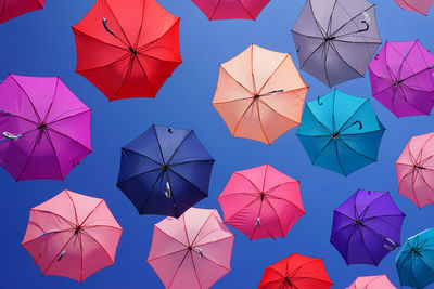 Full frame shot of multi colored umbrellas against blue sky