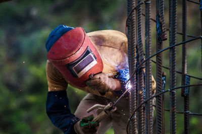 Close-up of man welding metal outdoors
