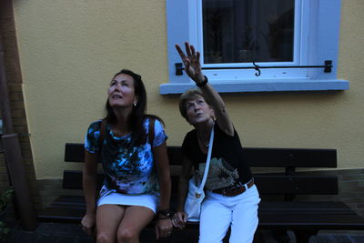 Full length of happy young woman with arms outstretched at night