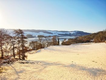 Scenic view of snow covered land against clear sky