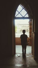 Silhouette man standing in window
