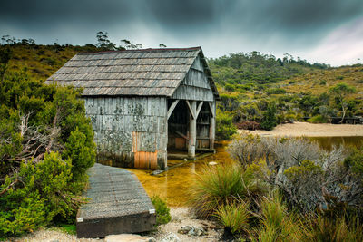 Built structure by lake against sky