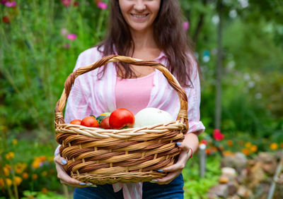 Portrait of young woman holding wicker basket