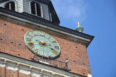 Low angle view of clock tower against building in city