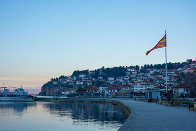 Scenic view of sea and buildings against clear sky during sunset
