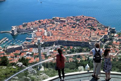 High angle view of people looking at view while standing by railing