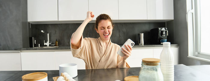 Portrait of young woman drinking coffee at home