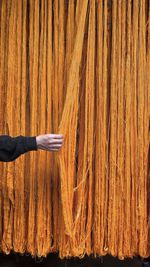 Cropped hand of woman standing against wall