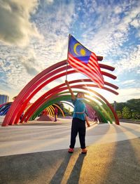 Rear view of woman standing against cloudy sky