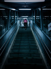 Rear view of man walking on staircase