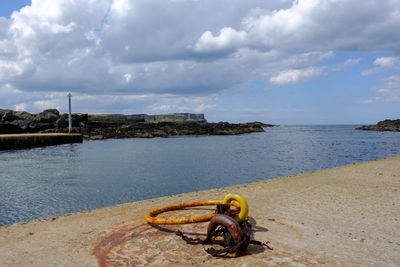 Boat on beach by sea against sky