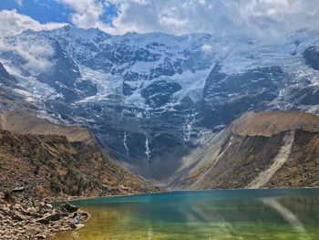 Aerial view of lake by snowcapped mountains against sky