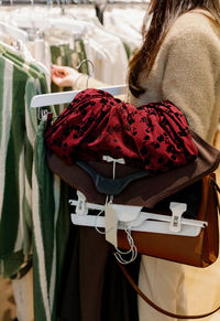 A young girl with an armful of things in her hands in a store.