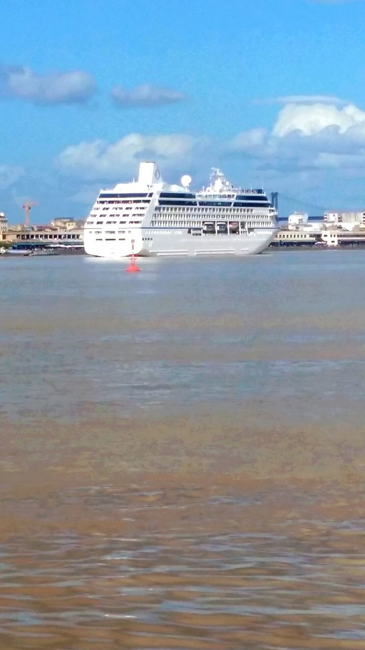 nautical vessel, water, transportation, sky, mode of transport, sea, cloud, blue, freight transportation, city, scenics, waterfront, ship, cloud - sky, commercial dock, harbor, industry, development, cruise ship, shipping, nature, day, tranquility, outdoors, in front of, tranquil scene, beauty in nature