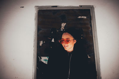 Portrait of smiling boy standing against wall