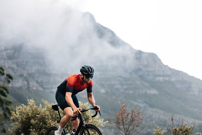 Rear view of man riding bicycle on mountain