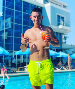 Full length of shirtless man standing in swimming pool