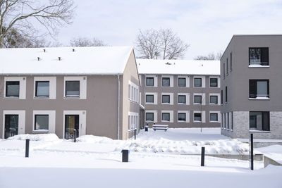 Snow covered houses and buildings against sky