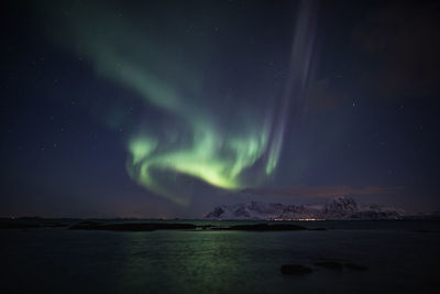 Scenic view of lake by mountain against sky at night