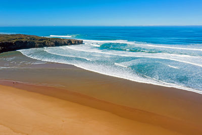 Scenic view of beach against blue sky