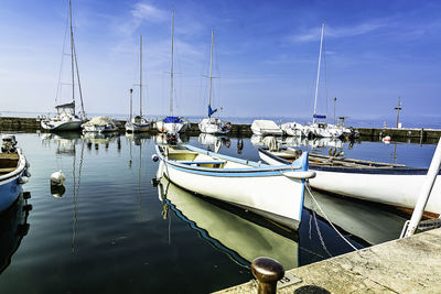 Sailboats moored in harbor