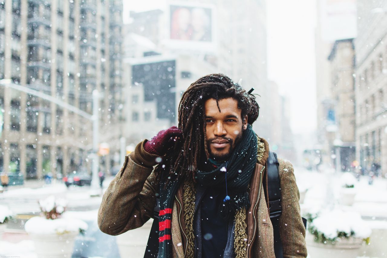 winter, cold temperature, weather, snow, real people, warm clothing, one person, front view, focus on foreground, lifestyles, outdoors, street, leisure activity, young adult, scarf, day, city, snowing, motion, built structure, young women, happiness, architecture, building exterior, nature, people