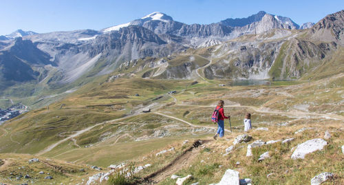 Rear view of man walking on mountain against sky