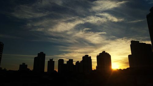 Silhouette buildings against sky during sunset