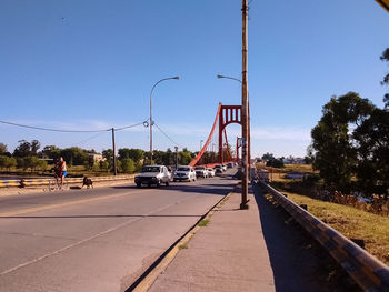 Cars on road against clear blue sky
