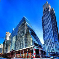 Low angle view of modern buildings against clear blue sky