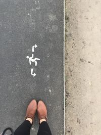 Low section of man standing on road