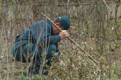 Side view of man working in forest