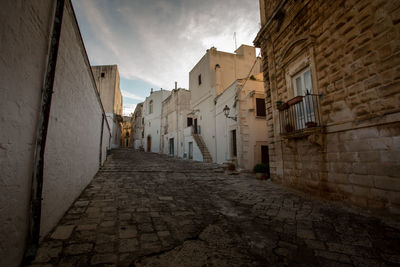 Narrow alley amidst buildings against sky