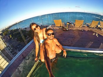 High angle portrait of smiling couple in swimming pool