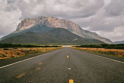 An empty highway against the background of mount ololokwe in marsabit county, kenya